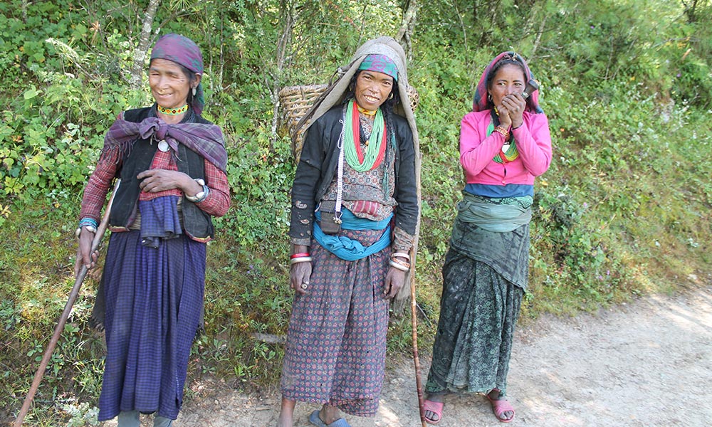 Indigenous women, dressed with their traditional ornaments and smoking pot